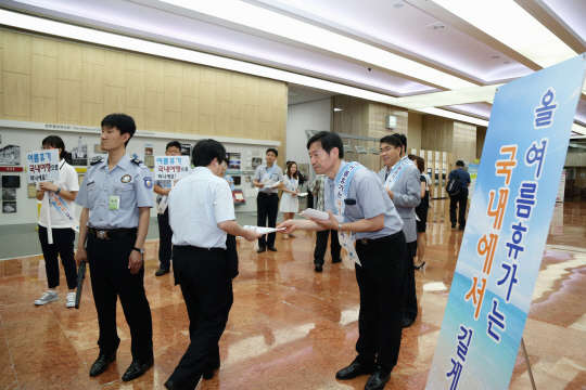 행정자치부 공무원들이 20일 서울 종로구 정부서울청사에서 '여름휴가 국내로 가기 및 에너지절약 캠페인'을 펼치고 있다. 행정자치부 제공.